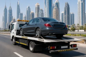 Mercedes sedan being transported on a flatbed tow truck along a Dubai highway, showcasing professional Mercedes towing and emergency repair services in Al Quoz for fast roadside assistance and vehicle recovery.