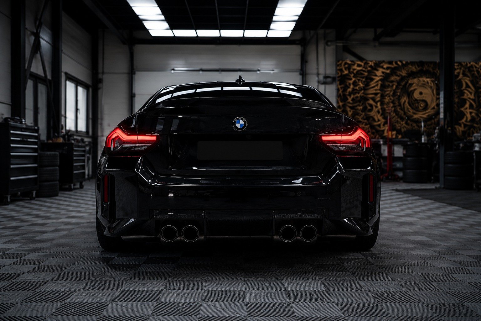 Rear view of a sleek BMW sports sedan inside a modern automotive facility, showcasing its distinctive BMW badge, illuminated taillights, and premium design. The professional setting reflects the high standards of a BMW workshop in Dubai, specializing in expert maintenance, diagnostics, performance upgrades, and luxury vehicle servicing.