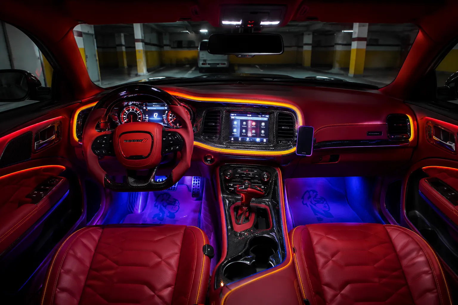 A premium Dodge sports car interior features a bold red leather dashboard, illuminated ambient LED lighting, a digital instrument cluster, carbon-fiber trim, and a modern infotainment display. This high-performance cockpit reflects the comfort and technology maintained through professional Dodge AC repair, ensuring a comfortable driving experience in all conditions.