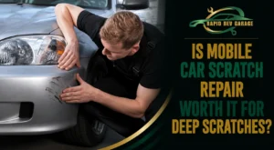 A mechanic inspecting deep scratches on a silver car as part of mobile car scratch repair.